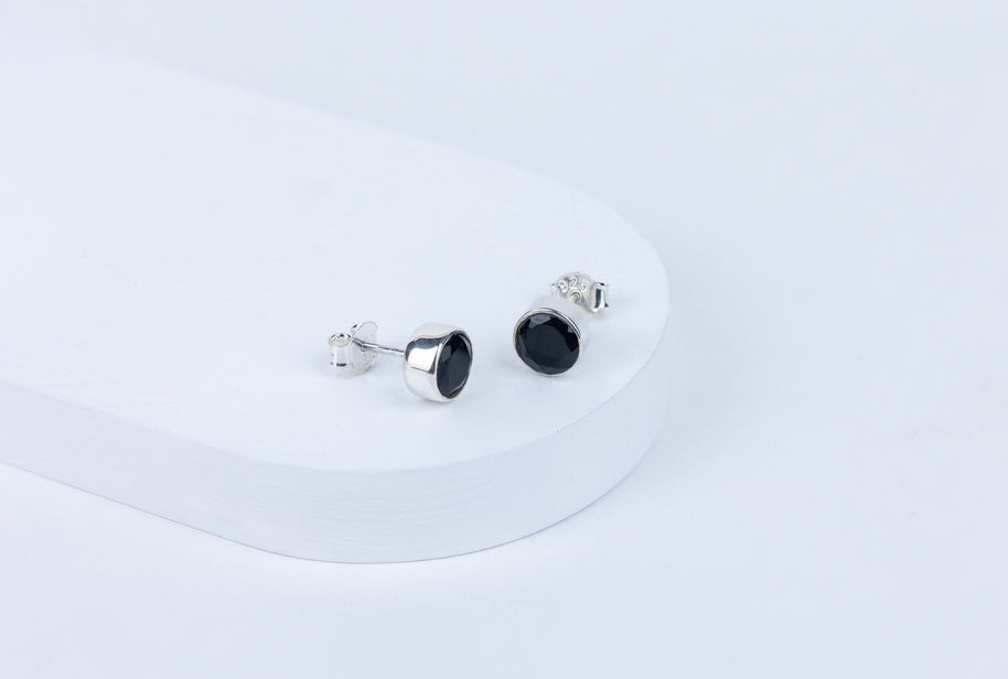 Pair of black stud earrings on a white background