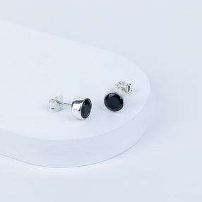 Pair of black stud earrings on a white background