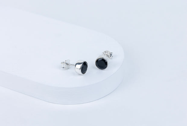 Pair of black stud earrings on a white background