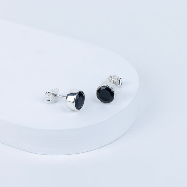 Pair of black stud earrings on a white background