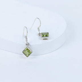 Peridot gemstone earrings on a white background