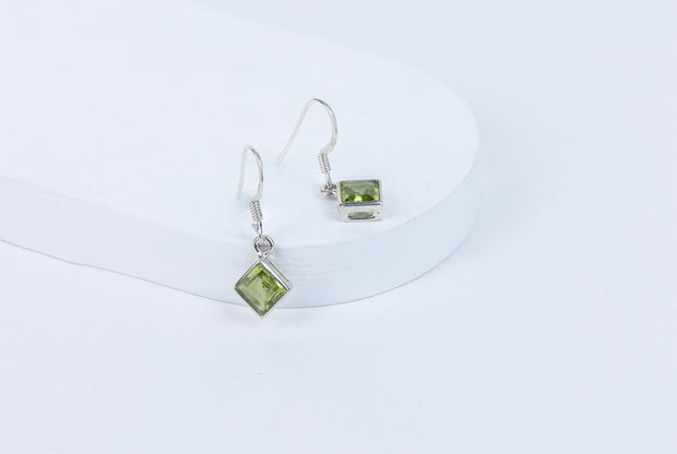 Peridot gemstone earrings on a white background