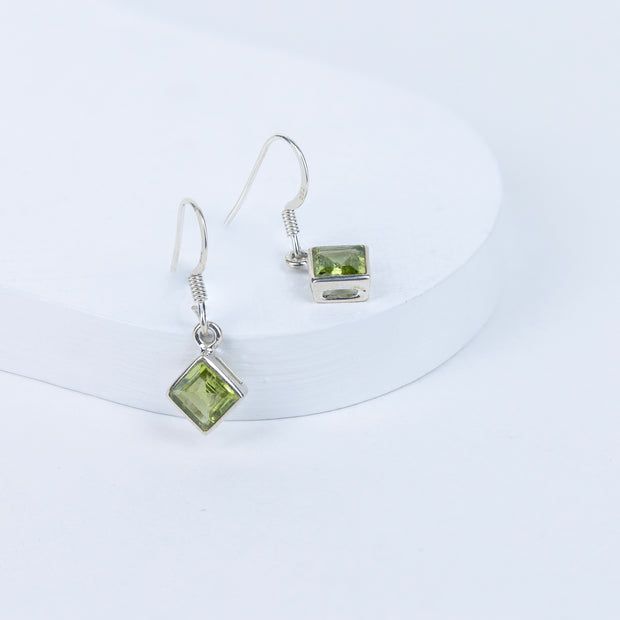 Peridot gemstone earrings on a white background