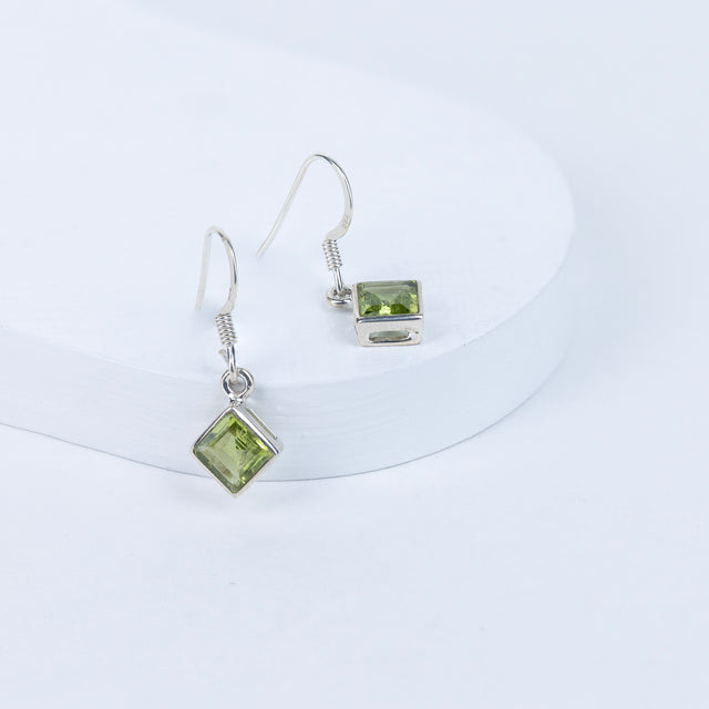 Peridot gemstone earrings on a white background