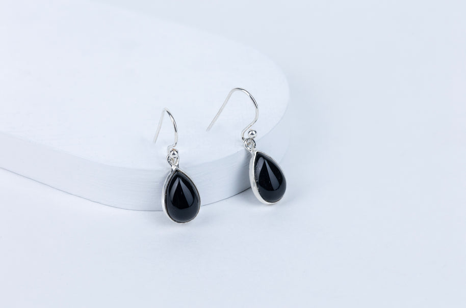 A pair of black tourmaline drop earrings with silver hooks, displayed against a white background.