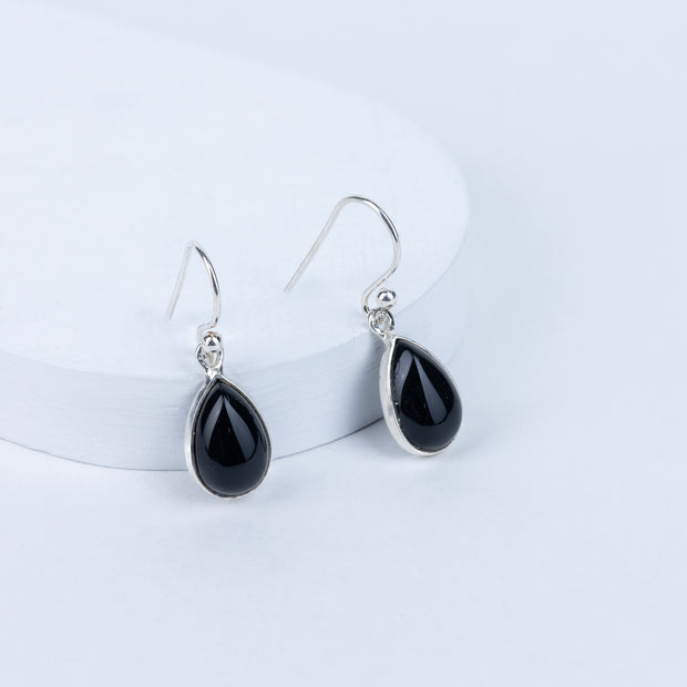 A pair of black tourmaline drop earrings with silver hooks, displayed against a white background.