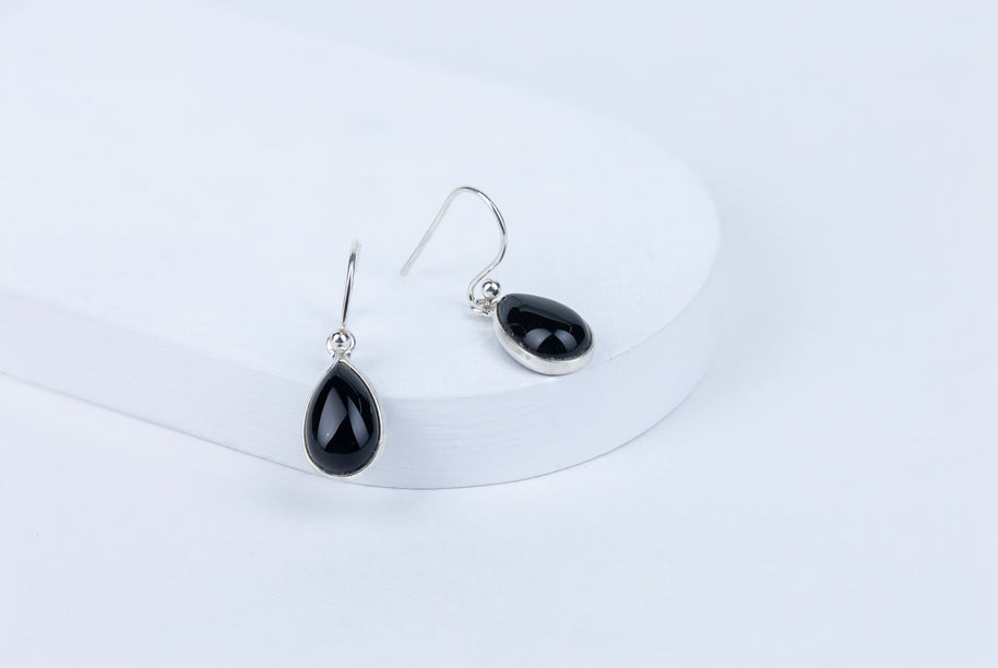 Black teardrop earrings on a white background
