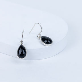 Black teardrop earrings on a white background