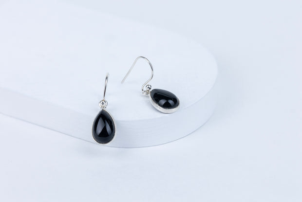 Black teardrop earrings on a white background