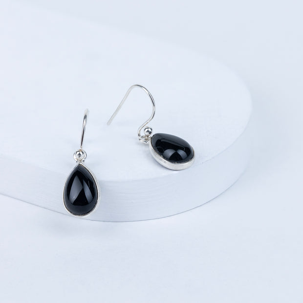 Black teardrop earrings on a white background