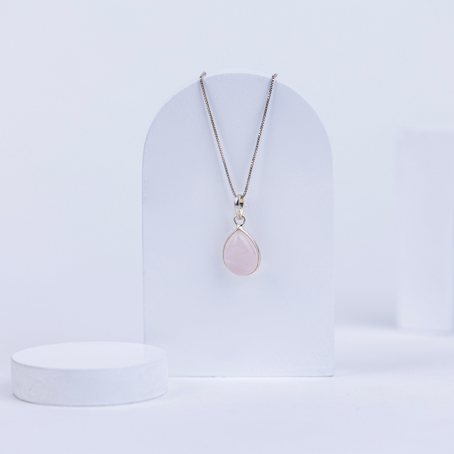 Necklace with a pink rose quartz pendant on a white background
