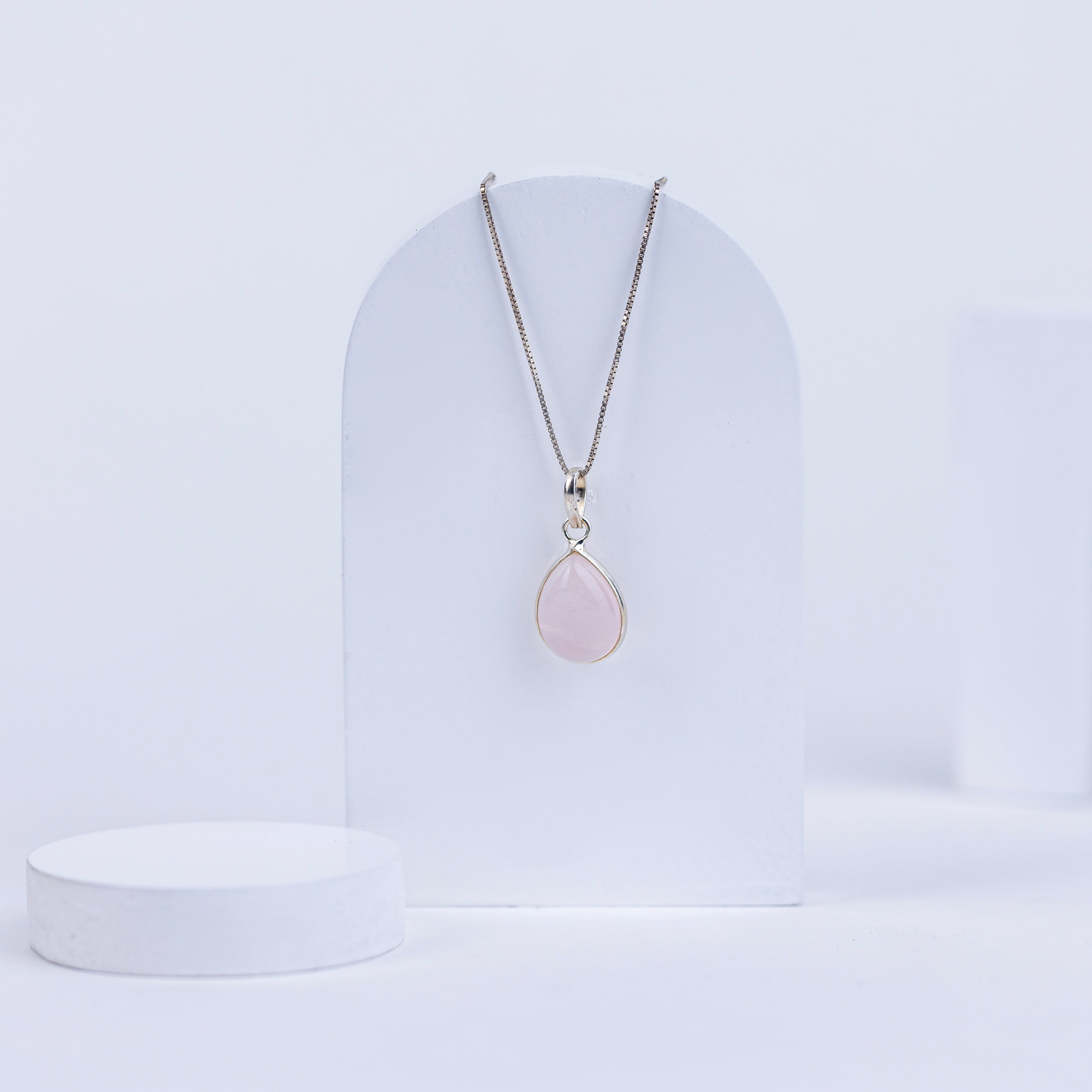 Necklace with a pink rose quartz pendant on a white background
